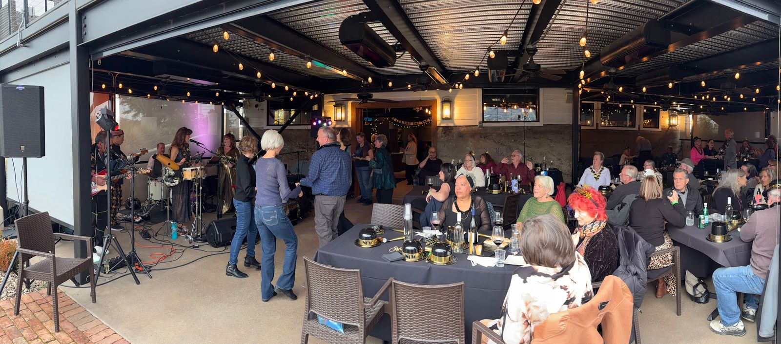 The NYE party at Naumes Suncrest Winery at 3:17 PM: the band playing on the left, guests at the tables under string lights